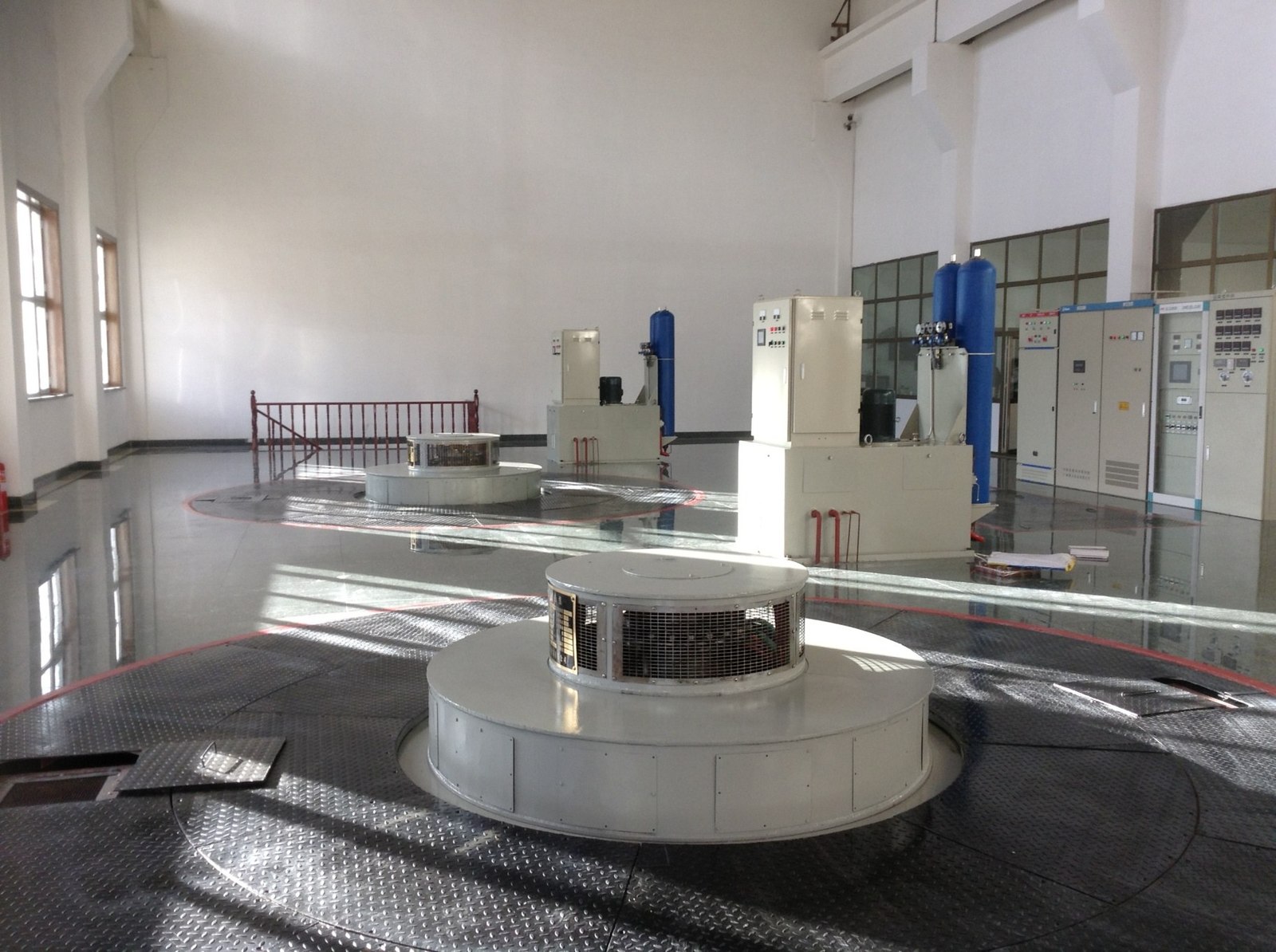 Generating floor of Kunlunqiao hydropower plant with vertical turbine-generator units and adjacent control cubicles
