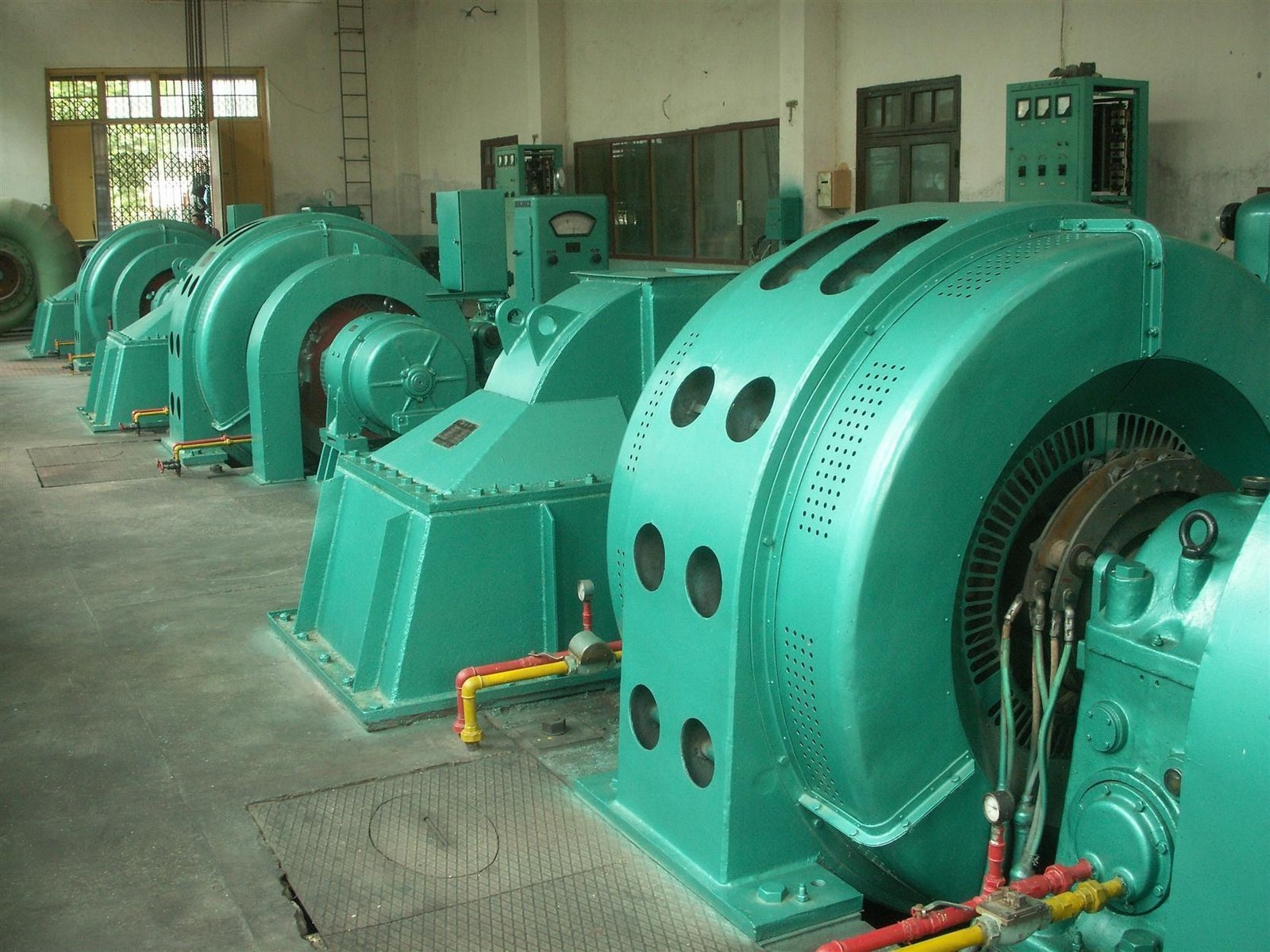 Impulse turbine hall with horizontal impulse turbine-generator units arranged in a row